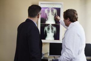 doctor-pointing-x-ray-result-beside-man-wearing-black-suit-2182972-min-300x200